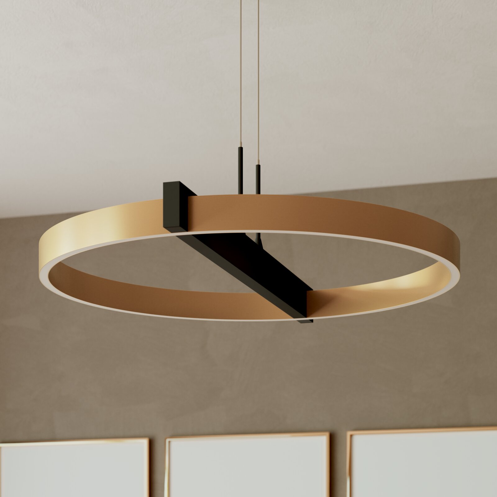 Moderne ringvormige hanglamp in goudkleur met zwarte dwarsbalk, van schuin onderen bekeken.