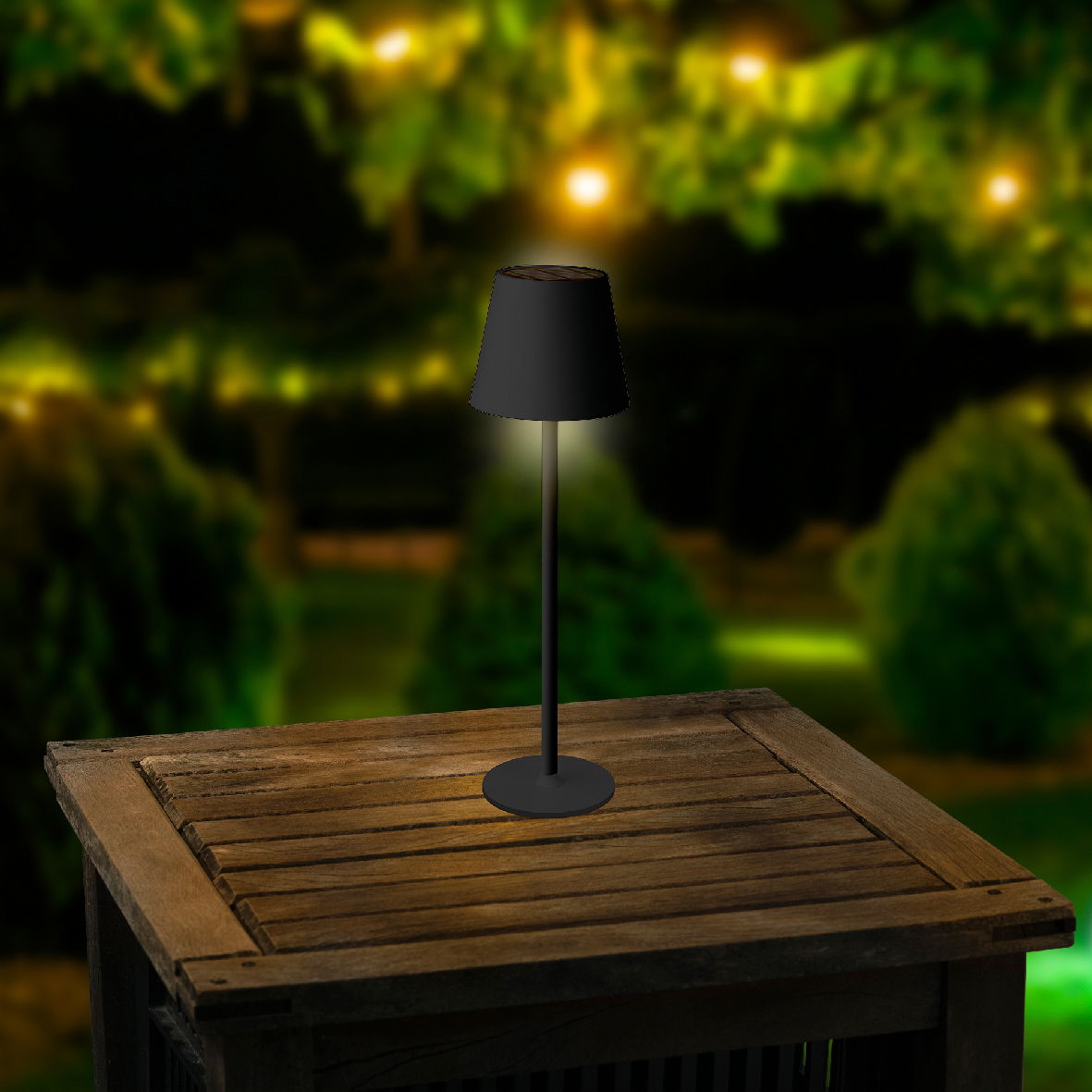 Solar Tischleuchte auf einem Holztisch im Freien, bei Nacht mit unscharfem, beleuchtetem Hintergrund, seitliche Perspektive