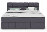 Frontale Ansicht eines modernen Boxspringbetts mit grauem Stoffbezug und zwei Kissen.