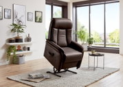 Moderne bruine relaxfauteuil in een lichte woonkamer met grote ramen, gezien vanaf de zijkant.