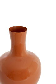 Nahaufnahme einer glänzenden, orangefarbenen Vase mit schmalem Hals und bauchigem Körper, von oben betrachtet.