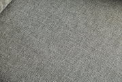 Nahaufnahme eines grauen Stoffbezugs mit feiner Webstruktur, perspektivisch von oben fotografiert.