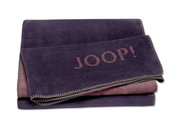 Gefaltete Decke in Lila mit dem Schriftzug 'JOOP!' in der Mitte, von oben fotografiert.