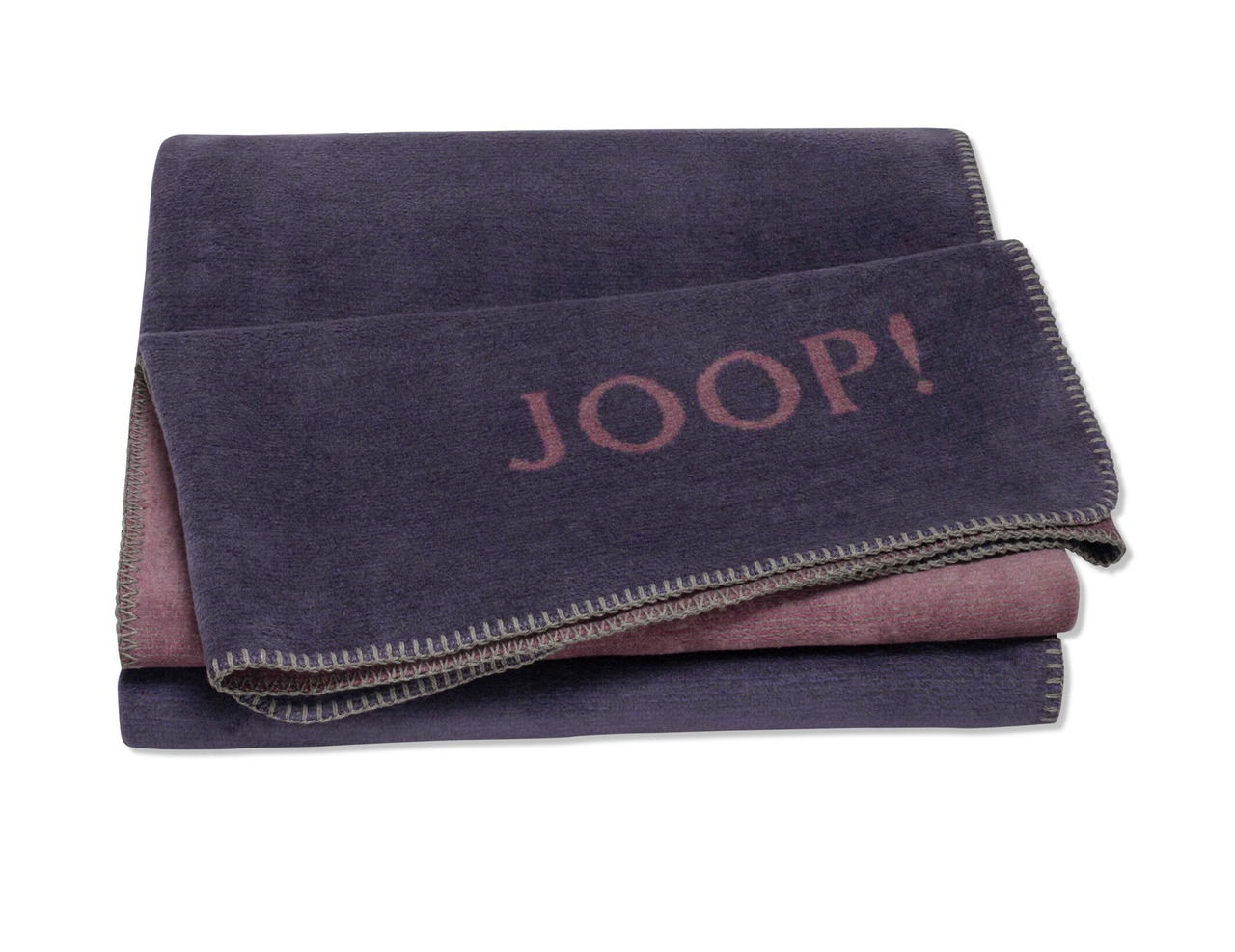 Gefaltete Decke in Lila mit dem Schriftzug 'JOOP!' in der Mitte, von oben fotografiert.