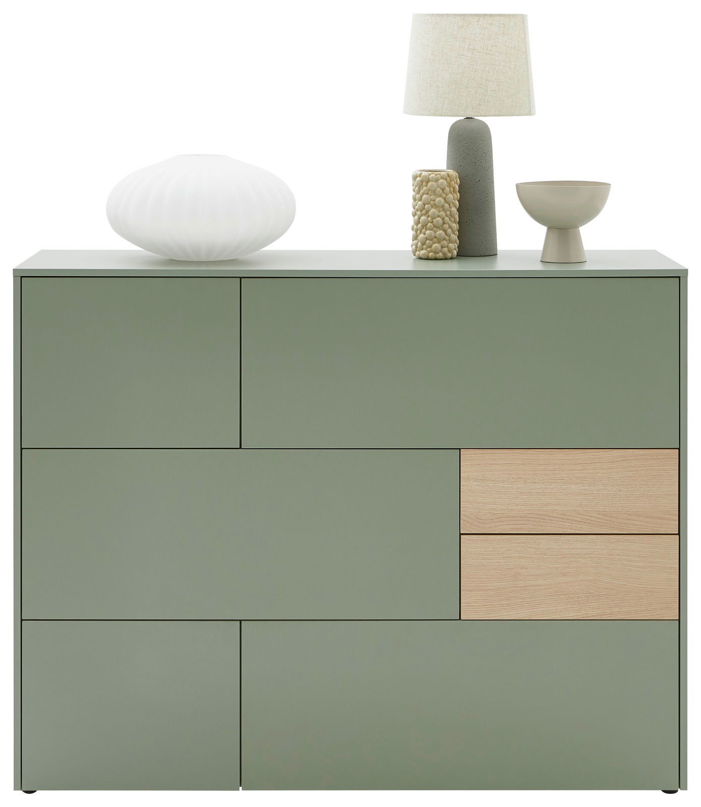 Frontansicht eines modernen, grünen Highboards mit Holzdetails, dekoriert mit einer Lampe, einer Vase und einer Schale.