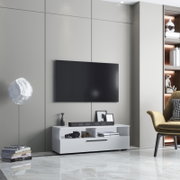 Modernes Wohnzimmer mit an der Wand montiertem Flachbild-TV über einem weißen TV-Lowboard mit Soundbar und Deko, seitliche Frontansicht in leichter Untersicht.