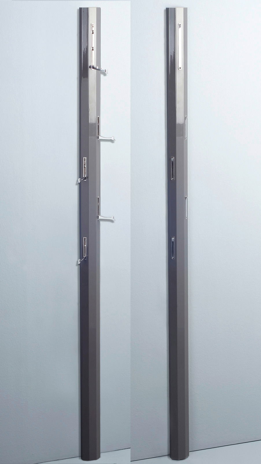 Zwei Garderobenpaneele in dunklem Grau, eines mit ausgeklappten Haken, das andere mit eingeklappten Haken, seitliche Perspektive.