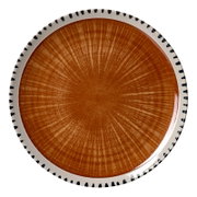Rond keramisch bord met warm oranjebruin stralenmotief en crèmekleurige rand met zwarte accenten, van bovenaf gezien