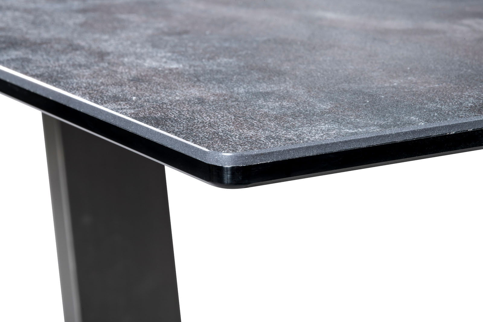Nahaufnahme einer Couchtisch-Ecke mit dunkler, strukturierter Tischplatte und stabilen, schwarzen Beinen.