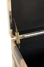 Detailaufnahme aus schräger Seitenperspektive: Messingfarbener Klappbeschlag/Scharnier an einer geöffneten Holztruhe mit schwarzem Innenfutter.