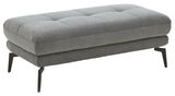 Grauer XXL-Hocker mit gepolsterter Sitzfläche und schwarzen Metallbeinen, seitliche Perspektive