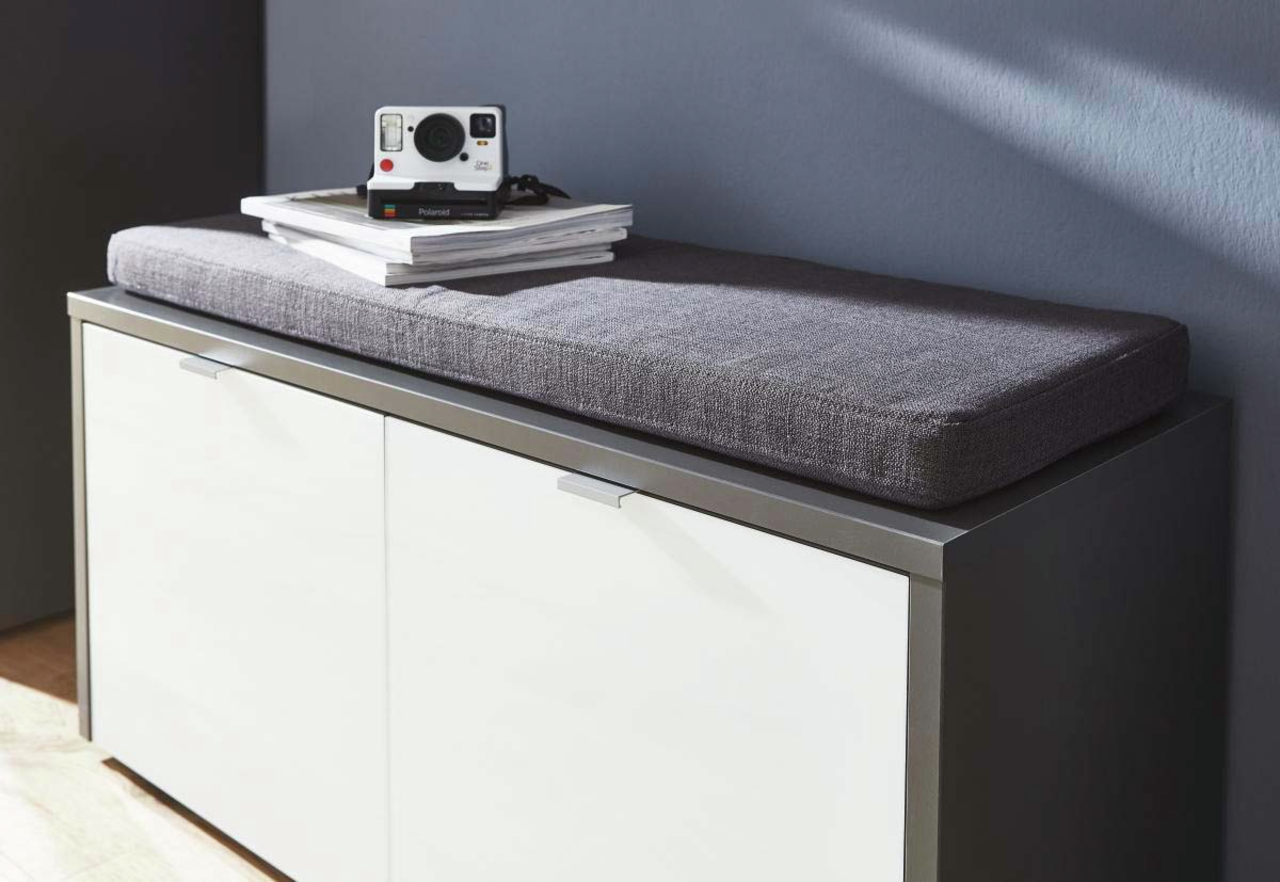 Graues Sitzkissen auf einem weißen Schrank, seitliche Perspektive