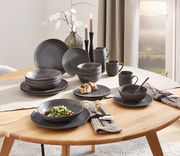 Elegantes 20-teiliges Kombiservice in dunklem, strukturiertem Design, auf einem gedeckten Tisch von schräg oben fotografiert.