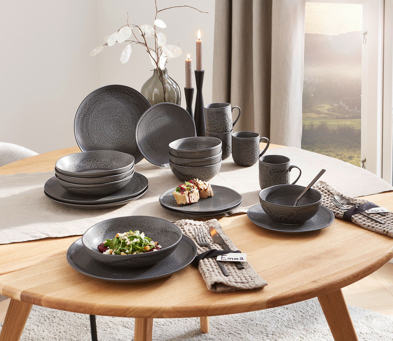 Elegantes 20-teiliges Kombiservice in dunklem, strukturiertem Design, auf einem gedeckten Tisch von schräg oben fotografiert.