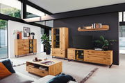 Moderne Wohnzimmermöbel aus Holz, bestehend aus einem Sideboard, Highboard, Wandboard und Couchtisch, in einem hellen Raum mit großen Fenstern, seitliche Perspektive.