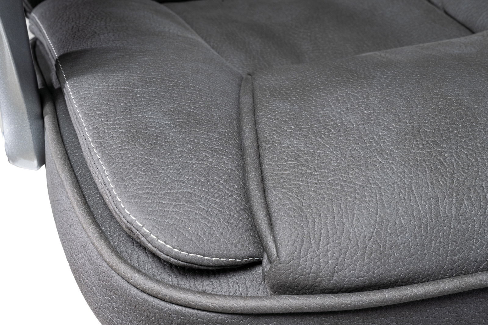 Nahaufnahme der Sitzfläche eines Chefsessels aus grauem Leder mit sichtbaren Nähten, seitliche Perspektive.