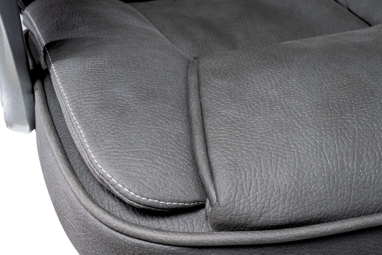 Nahaufnahme der Sitzfläche eines Chefsessels aus grauem Leder mit sichtbaren Nähten, seitliche Perspektive.