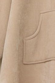 Nahaufnahme eines beigen Lounge Hoodies mit einer Tasche, seitliche Perspektive