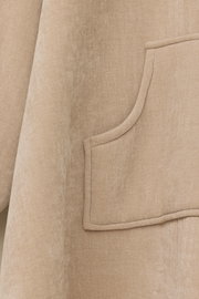 Nahaufnahme eines beigen Lounge Hoodies mit einer Tasche, seitliche Perspektive